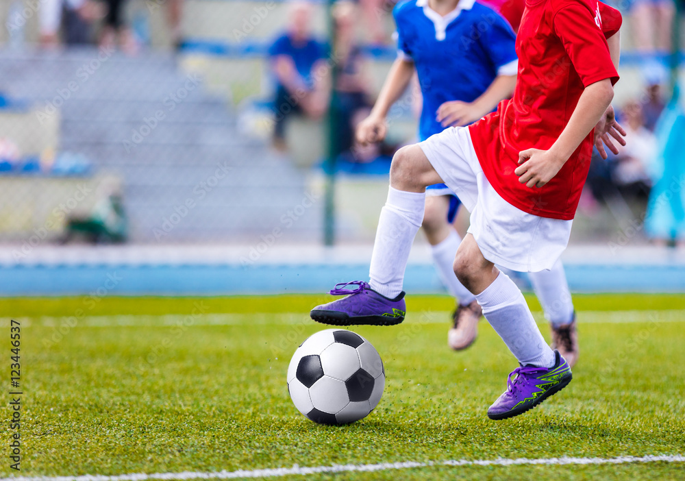 Young boys playing soccer match. Kids kicking football on sports field Young boys playing soccer match. Kids kicking football on sports field