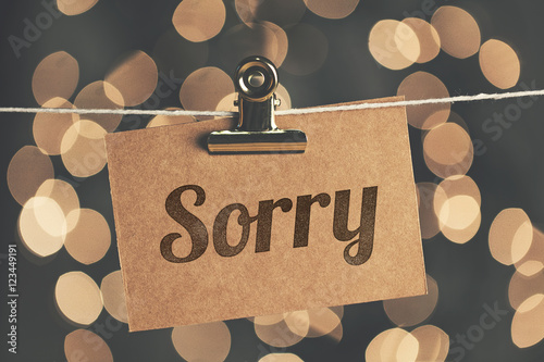 Sorry sign pegged to a string with blurred bokeh lights in the background