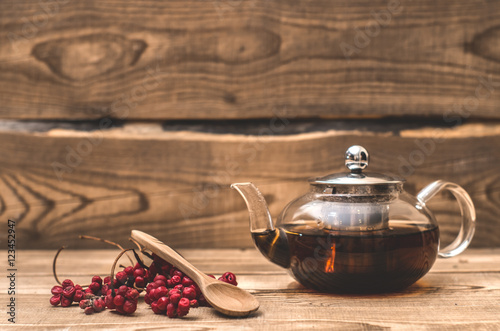 Transparent teapot and Schisandra berries on wooden boards