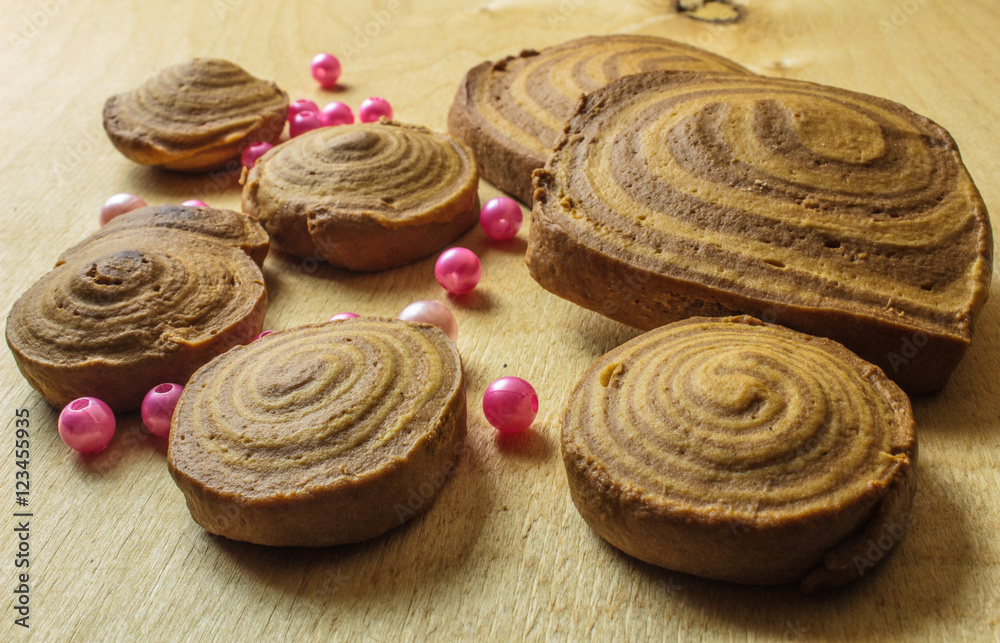 homemade cookies spiral with beads on a light wooden background