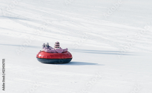 child riding on the tubing (inflatable sledges)