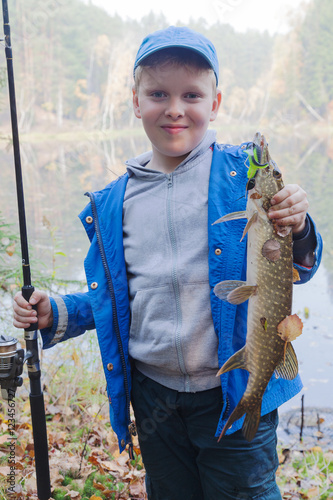 Happy angler with pike fishing trophy