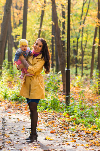 happy family mother and baby laugh with leaves in nature autumn