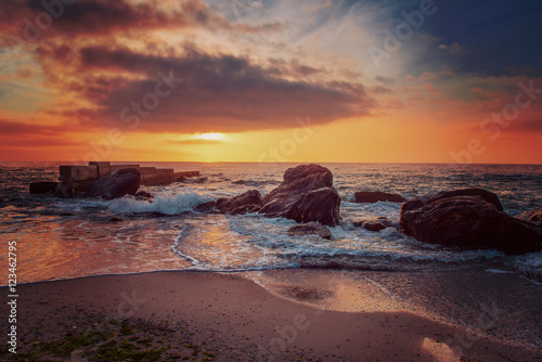 Sea coast after sunrise with rocks  blue water and sunny sky  natural seasonal summer hipster background