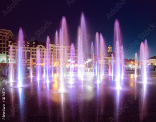 Musical fountain with colorful illumination at night with reflection. Ukraine, Kiev. Travel entartainment sightseeing background