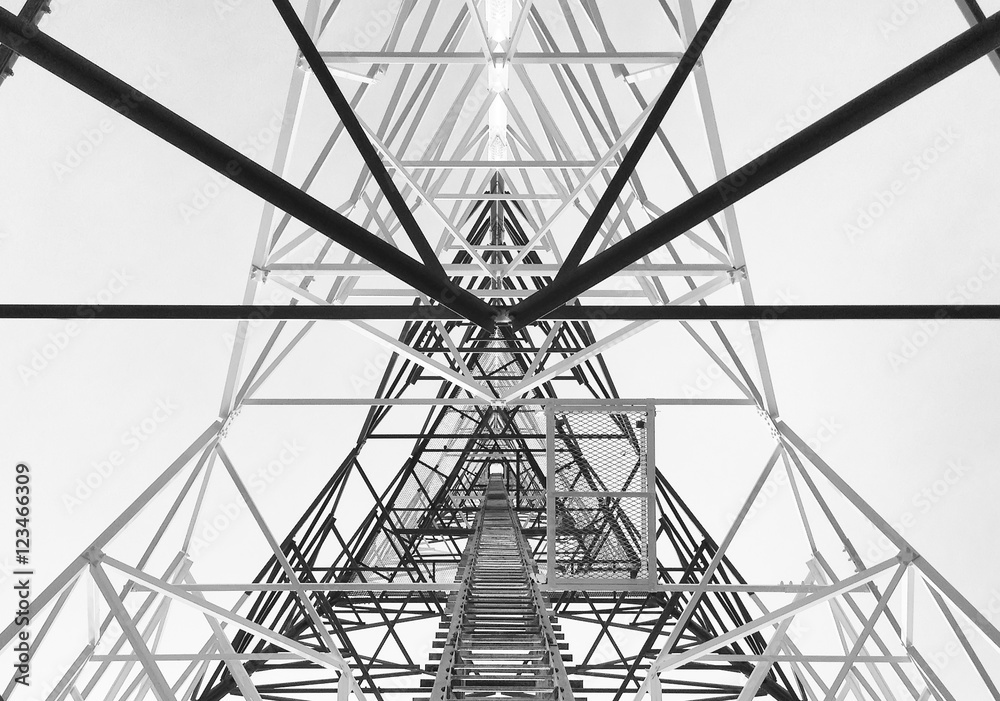 Fototapeta premium Newly completed telecommunication tower with white and red paint, step ladder in black and white format