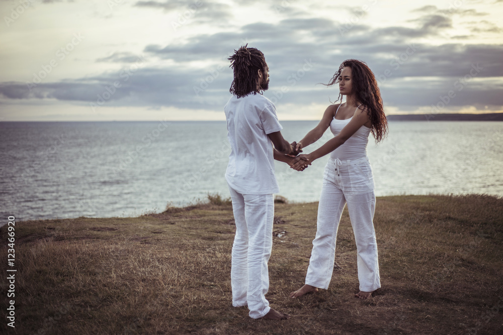 Couple holding hands while standing on field Couple holding hands while standing on field