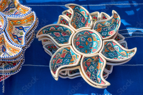 Colorful handmade ceramic pottery on the blue table-cloth photo