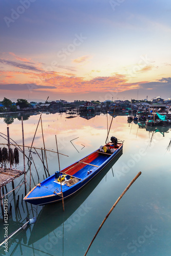 Fishing boats in harbor with sunrise