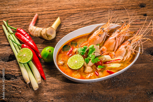 Tom Yum Goong Thai hot spicy soup shrimp  with lemon grass,lemon,galangal on wooden background Thailand Food