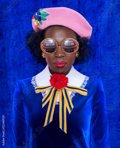 Woman wearing pink beret, blue dress and sunglasses