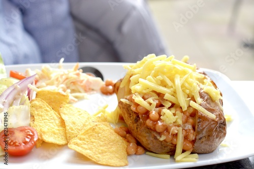 Jacket potato stuffed with baked beans and grated cheese served with a side salad and tortilla chips 