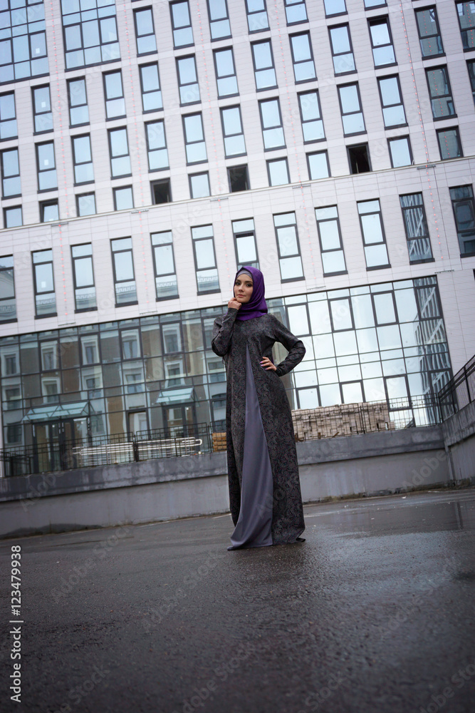 Young Muslim woman in oriental dress on a background of a modern building Young Muslim woman in oriental dress on a background of a modern building