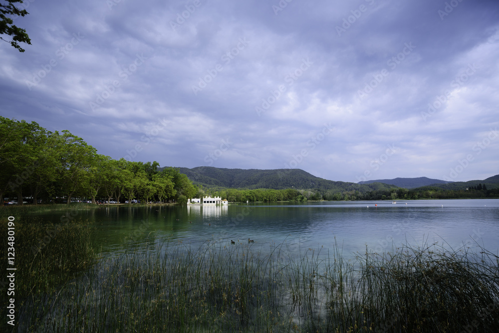 Lake Banyoles is the largest lake in Catalonia, Tourists enjoy the good weather and relax for boating and wooded paths.