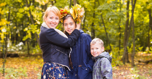mother with daughter and son in sunny autumnal park