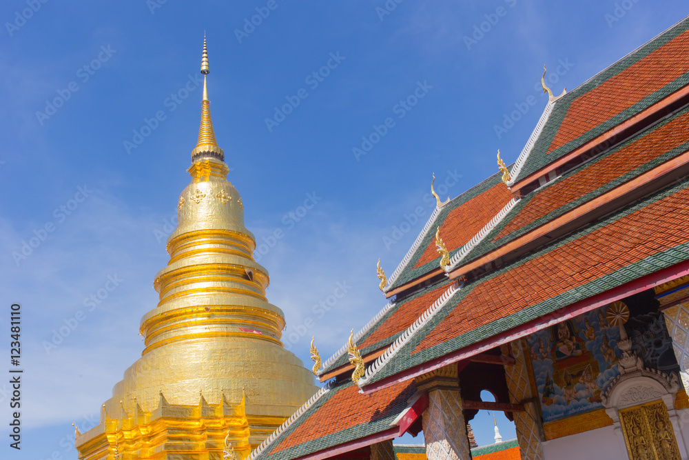 Fototapeta premium Thai Golden pagoda and Chapel Roof Wat Phrathat Hariphunchai Woramaha vihan, Lamphun, THAILAND.