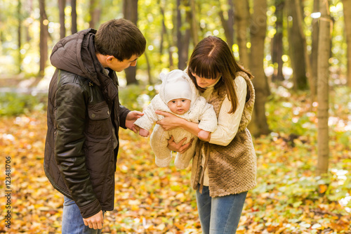 young family with their newborn baby spending time outdoor in the autumn park. © satura_