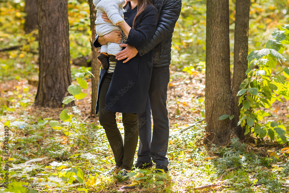 young family with their newborn baby spending time outdoor in the autumn park. young family with their newborn baby spending time outdoor in the autumn park.