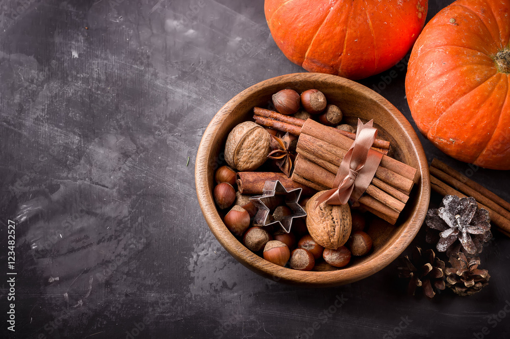  Fall harvest concept.Pumpkins, spices and nuts in wooden bowl.
