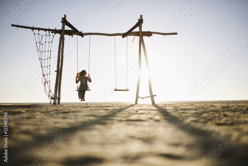 Woman on swing at sunset, Dakhla, Western Sahara Desert, North Africa photo