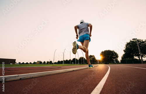 Man running on track, back view 