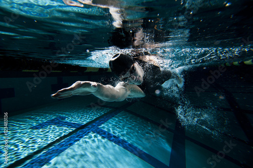 Woman swimming underwater in pool  photo