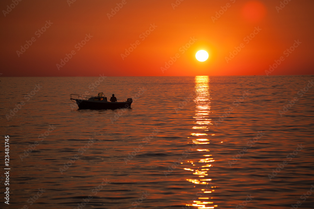 Fisherman in a boat during sunset