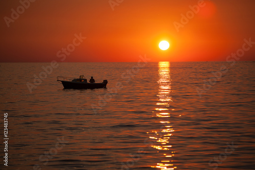 Fisherman in a boat during sunset © dimedrol68