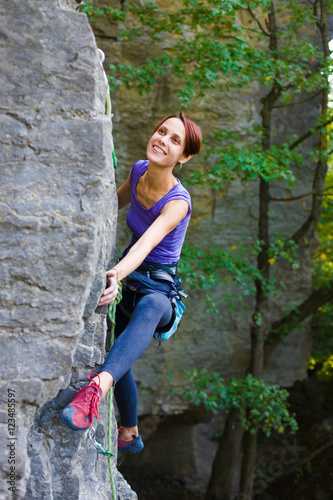 The girl climbs the rock.