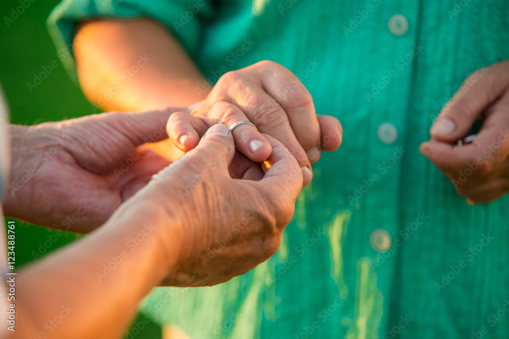 Man putting ring on lady. Hands of a senior couple. Fill your heart with love. Have no fear. Man putting ring on lady. Hands of a senior couple. Fill your heart with love. Have no fear.