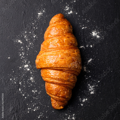 Fresh croissant Black slate background. Top view photo