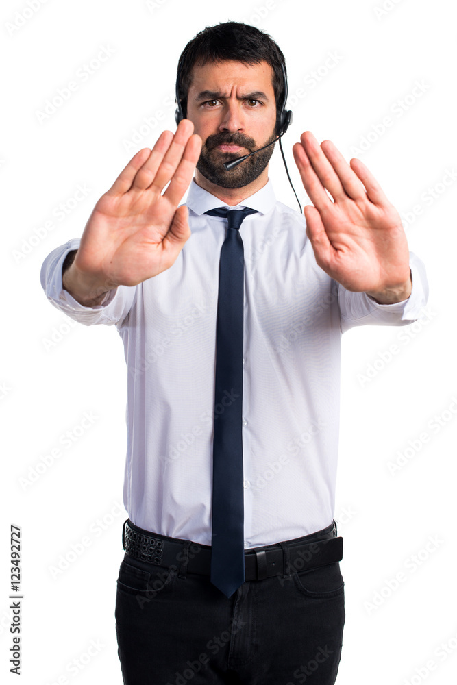 Young man with a headset making stop sign Young man with a headset making stop sign