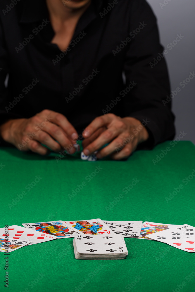 Gambling man in black shirt with dices in hands at playing table Gambling man in black shirt with dices in hands at playing table