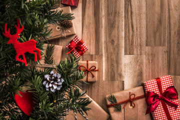Gifts under christmas tree on wooden floor. Top view with copy