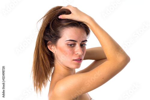 Woman standing sidewise and fixing hair