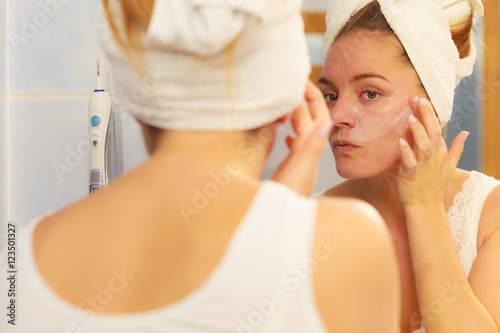 Fényképezés Woman applying mask cream on face in bathroom