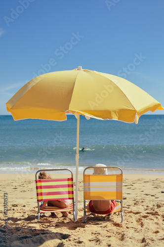 Back view of children having fun on the beach sunny outdoors background