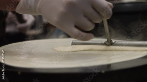 Hand With Special Tools Cooking Pancakes on the Plate.. the Action in Real Time.