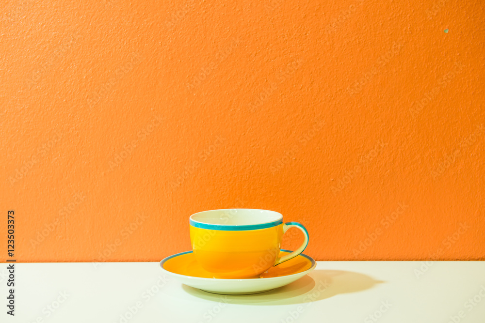Yellow coffee cup with orange wall - obrazy, fototapety, plakaty 