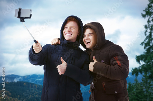 Young happy men taking self...