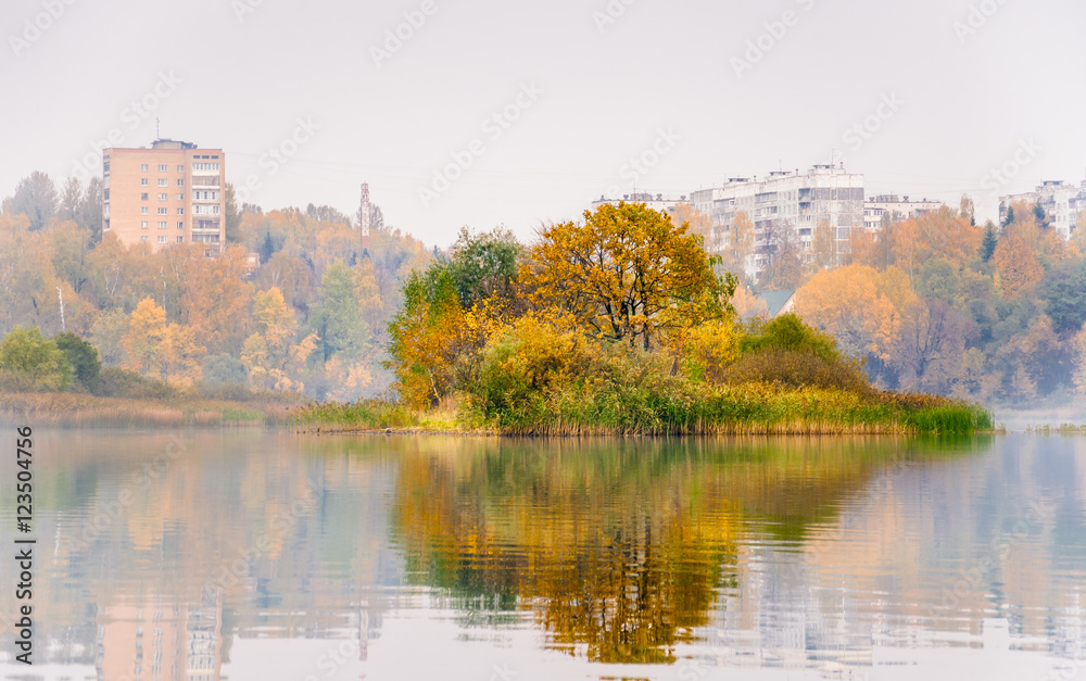 Fog on the lake Senezh in Solnechnogorsk fall in calm weather. The views of Raspberry island and high-rise residential houses of the city. Autumn water landscape