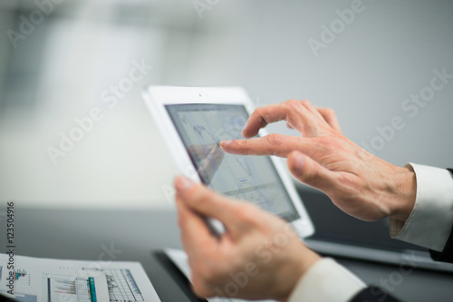 Businessman with finger touching screen of a digital tablet