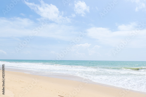 Empty sandy beach with sea under blue sky in thailand