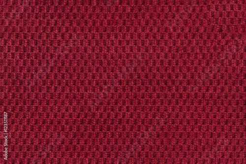 Red background from soft fleecy fabric closeup. Texture of textile macro.