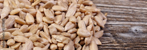Heap of sunflower seeds on wooden background
