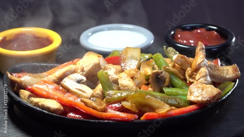 Black seramic lava Mexican Fajita guvec plate rotating with hot smoke steaming