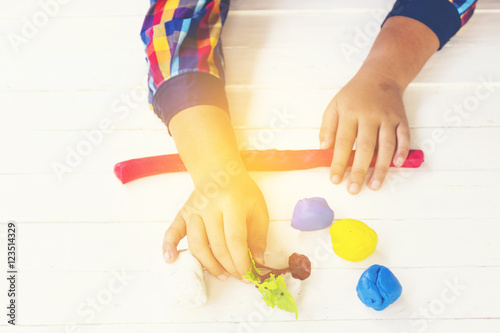 Child with Clay and using creativity for making red line and etc.Top view and Zoom in.