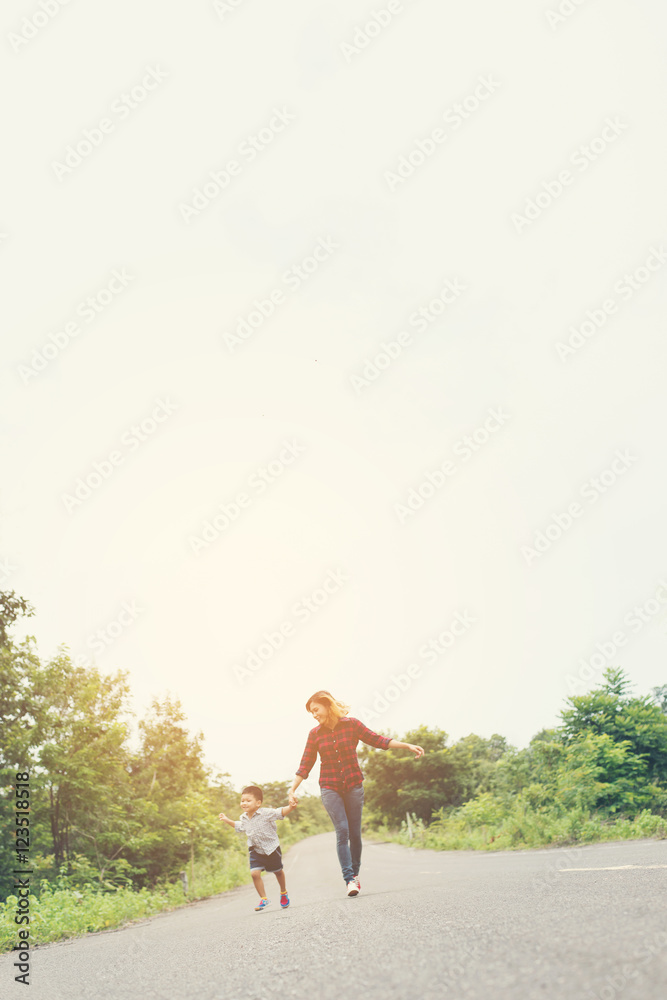 Little boy holding his mother hand running on the street enjoy g Little boy holding his mother hand running on the street enjoy g