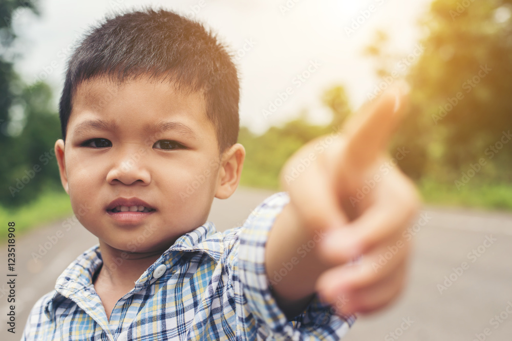 Portrait of cute asian boy pointing his finger to camera. Portrait of cute asian boy pointing his finger to camera.