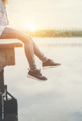 Hipster women feets laying on the lake relaxing with her holiday